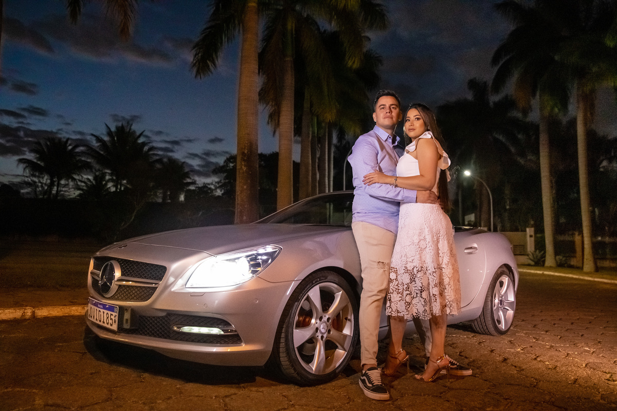 Com o carro do pai da noiva, eles fazem pose de filme, recostados no carro, com um finalzinho de céu azul e uma linda mercedes prata.