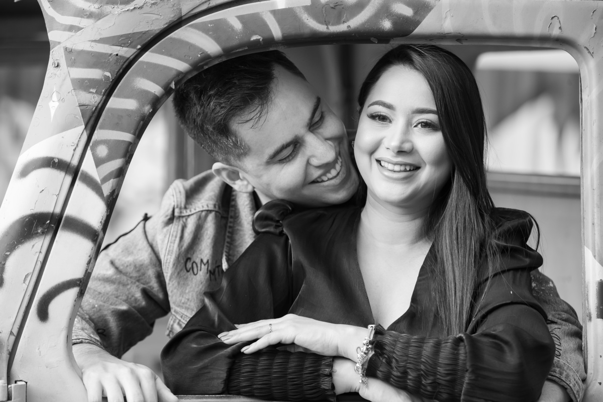 Quem nunca namorou dentro do carro...namorando dentro de uma kombi velha toda grafitada, os noivos sorrindo dentro dentro dela, tudo em uma linda fotografia preto e branca, feita por Sandro Andrade fotógrafo no DF.