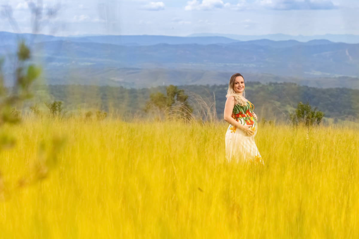 Lindo retrato colorido da Sarah no meio do mato dourado e e o serrado de fundo.