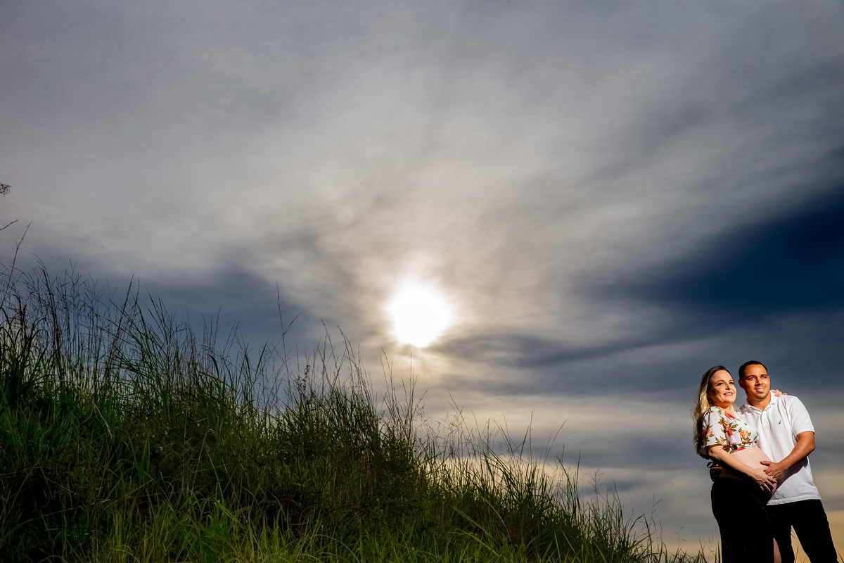 Ah...o céu! Esse lindo céu azul, com nuvens e o sol,  o casal a frente, Renato com a mão da barriga da esposa.