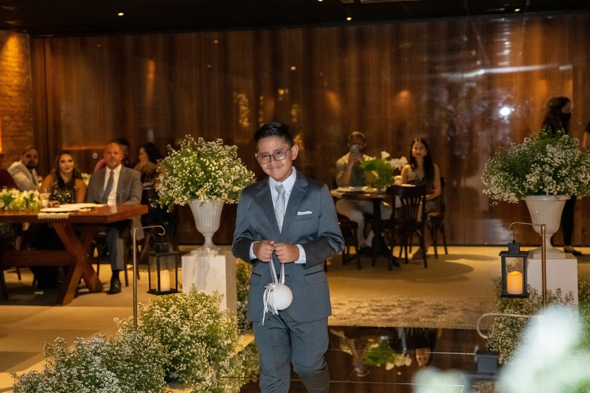 O filho da noiva, está entrando com as alianças, muito emocionado.