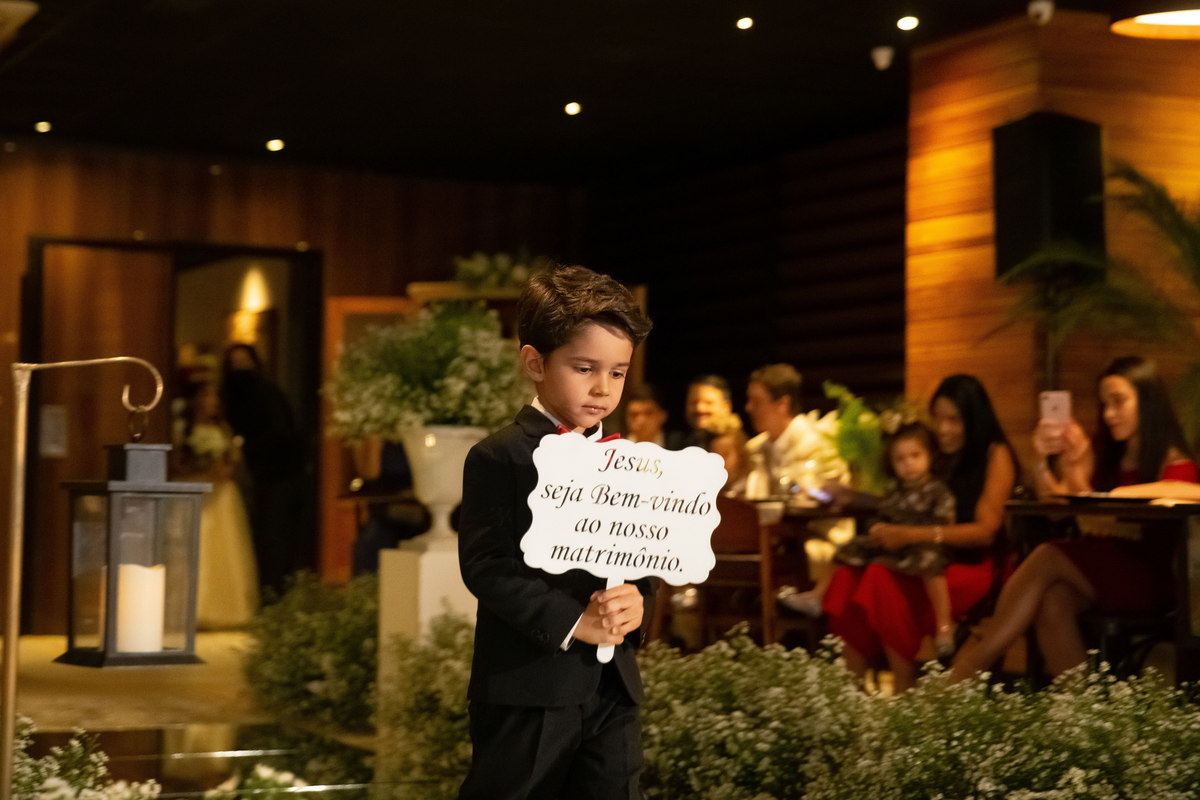 Entrada do Pajem com a plaquinha: Jesus, seja bem vindo ao nosso matrimônio.