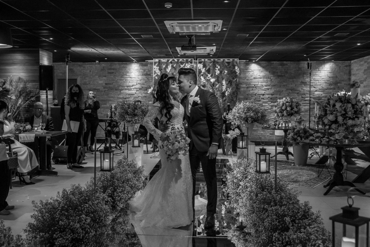 Um lindo beijo do casal, durante a saída deles, em preto e branco.