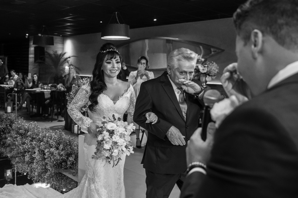 O pai da noiva e o noivo estão muito emocionados nesta linda fotografia do momento da entrega.