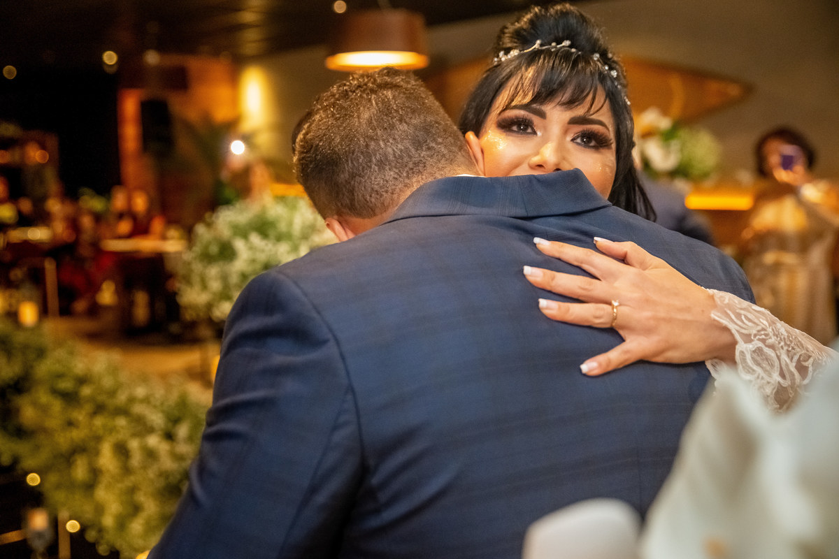 Retrato colorido dos noivos se abraçando.