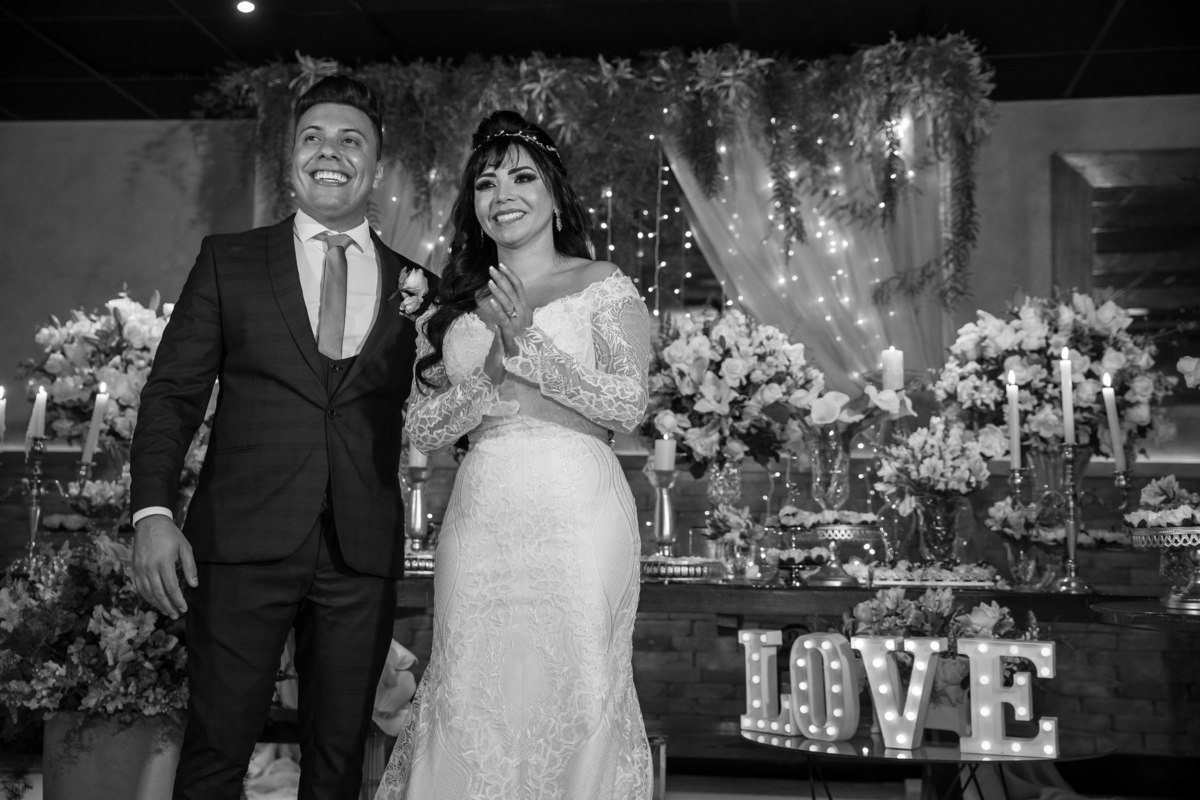 Após os agradecimentos, foi passado um video com os melhores momentos da cerimonia do casamento, nesta foto a noiva e o noivo estão juntos e ela aplaude o lindo video que estão assistindo.