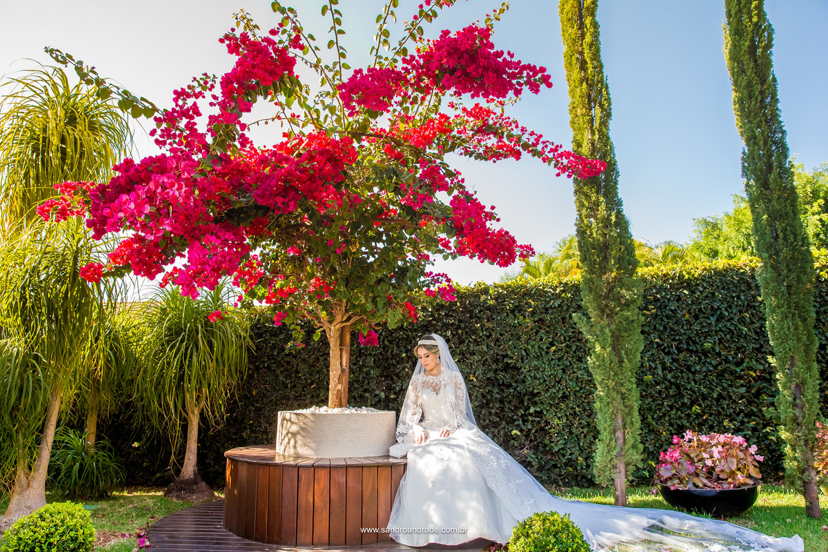 Olhando para baixo, a noiva Daiane, fica encantada com os detalhes de seu vestido de noiva.