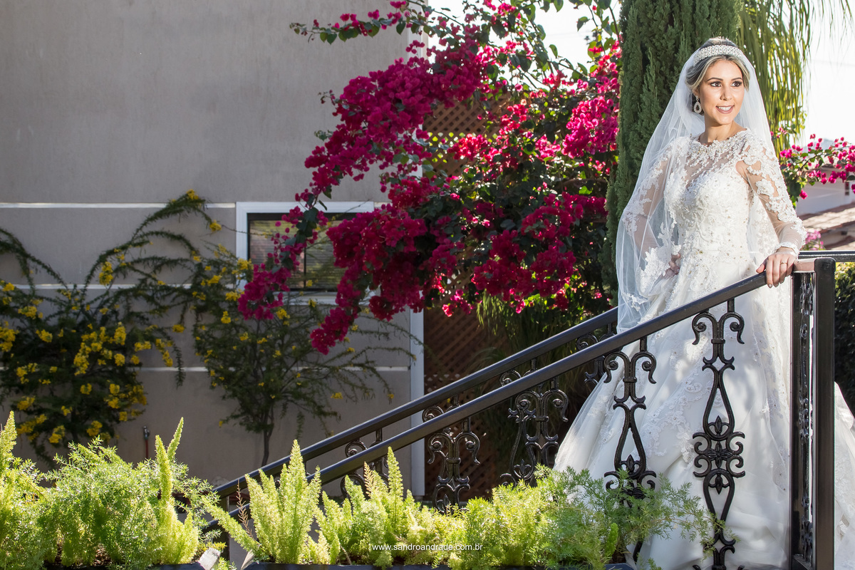 Já no finalzinho da prévia ela se solta um pouco mais e dá um sorriso mais descontraído, uma fotografia que mostra a noiva de corpo inteiro na escada do jardim.
