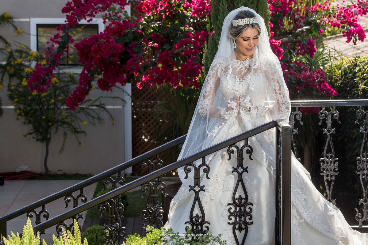 Lindo registro feito pelo fotógrafo de BSB, Sandro Andrade, Daiane está na escada em um lindo retrato olhando para baixo, segurando seu véu de noiva.