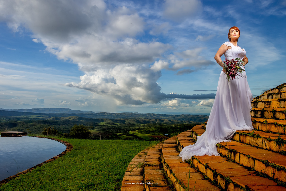 A noiva na escada do templo, com uma linda luz artificial trabalhada para ilumina-la e marcar bem este lindo céu bem azul, grama verdinha que parece até wallpaper do windows(risos) e muitas nuvens que formam um caminho até a noiva linda e ruiva.