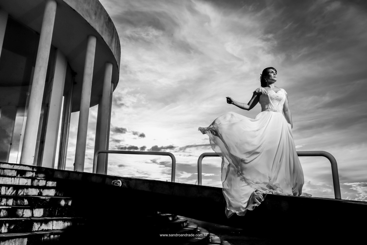 O fotógrafo de casamento DF, Sandro Andrade é muito atencioso aos detalhes e nesta linda imagem pb, Sandro colocou a noiva na rampa do Paraíso na Terra, aparecendo parte do templo e ela joga a saia do seu vestido, com o vento formando movimento perfeito.