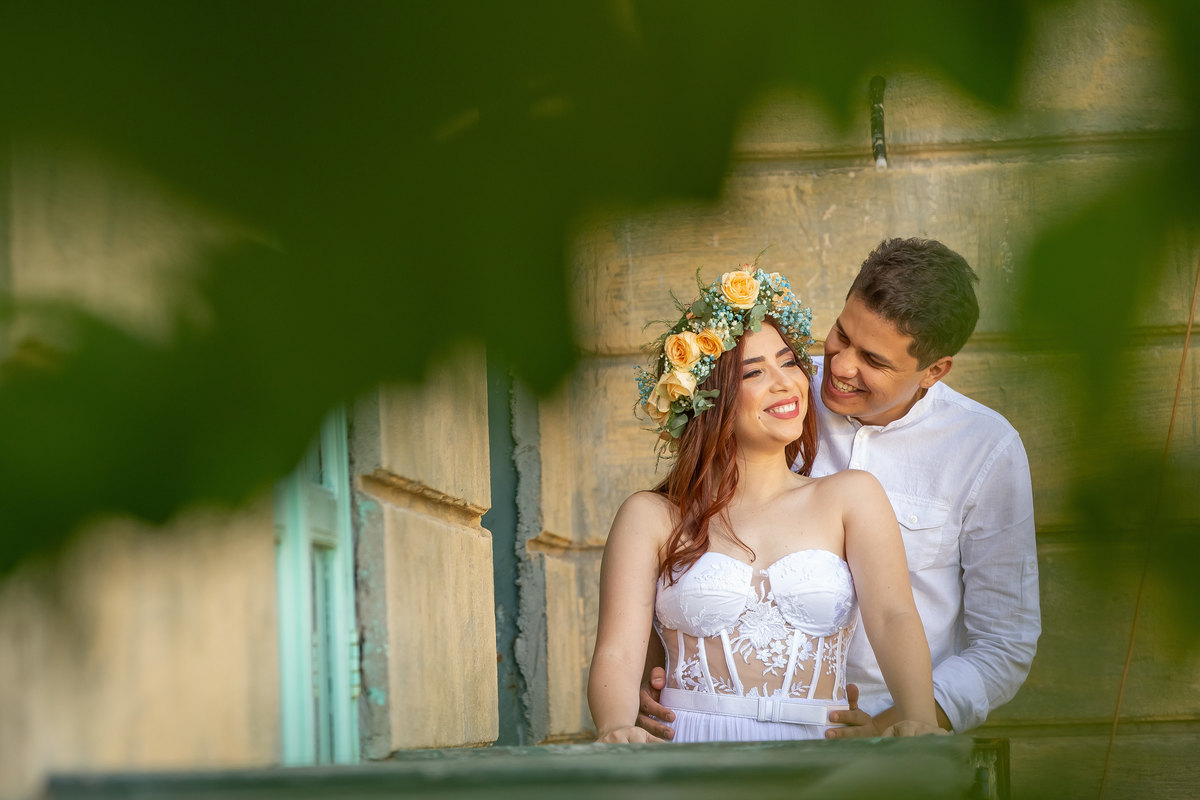 Em um cantinho, só eles e um lindo e leve colorido, descontraídos e sorrindo, Bruce olha apaixonado para sua linda noiva ruiva Jessy. Um retrato feito pelo nosso artista Sandro Andrade fotógrafo de casamentos em Brasília.