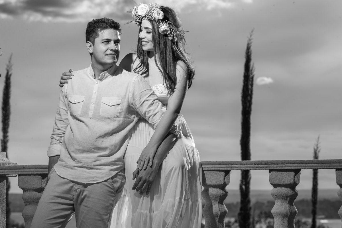 Em uma fotografia preto e branco, clássica, a noiva olha para seu noivo e ele olha lateral para os giardinos da Villa.