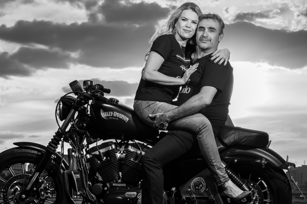 E para finalizarmos nosso ensaio, fomos com o casal para o meio ali do Plano, naquele parte verde entre a Catedral e os ministérios. Nesta fotografia pb, o casal está em cima da moto, bem abraçadinhos e olhando para as lentes do fotógrafo Sandro Andrade  