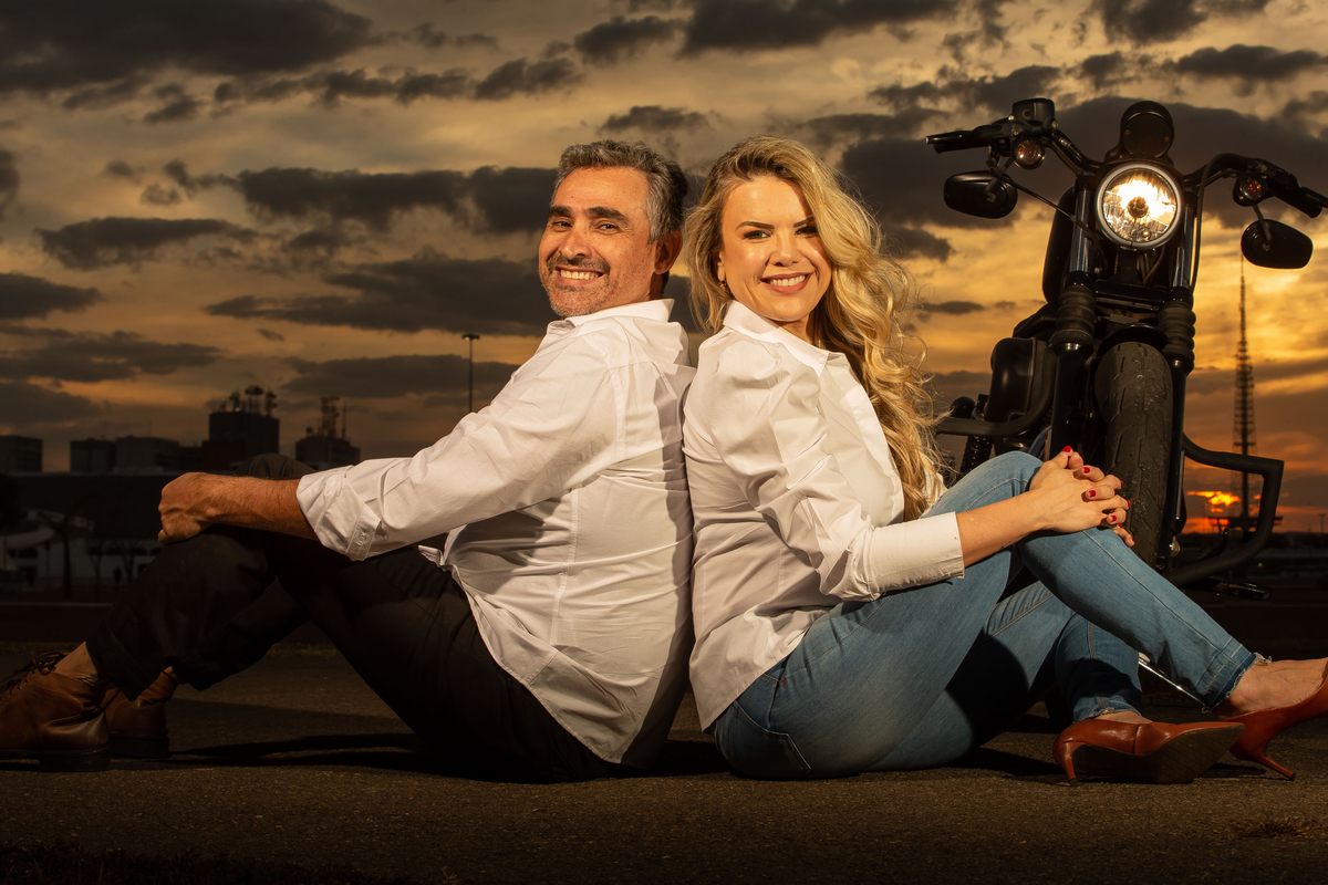 Sentados no chão, de costas um para o outro, moto atrás da Cris e os dois estão olhando para o Sandro Andrade fotógrafo de casamentos e ensaios no DF, o escolhido para registrar seu casamento, um momento especial na vida dos dois.