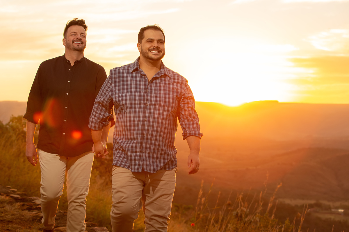 Felizes e caminhando de mãos dadas, bem descontraídos eles sorriem neste lindo retrato.