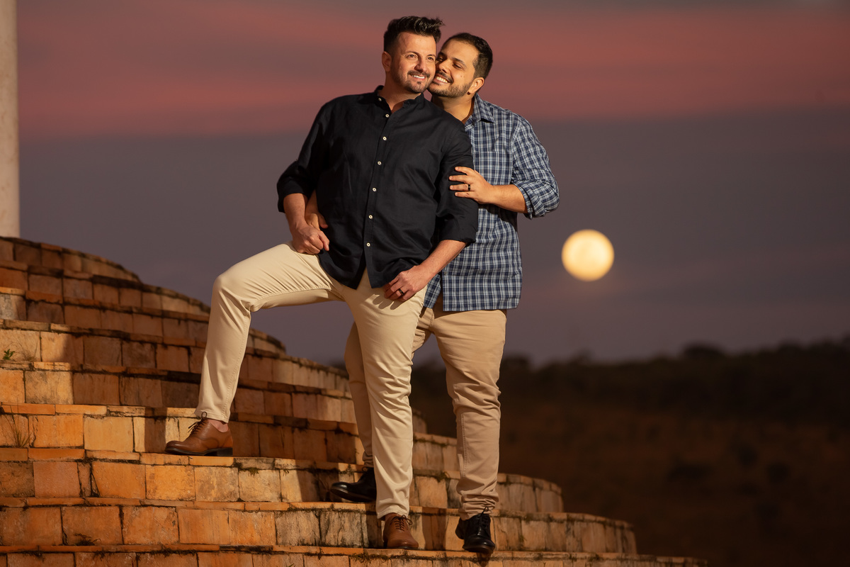 Posando de galã, Jorge olha o finalzinho do pôr do sol, enquanto Jorge o abraça por trás e dá um cheirinho nele.