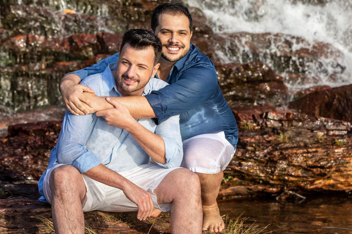 Um retrato lindo, essa coleção tem muitas fotos lindas, mas esta me passa um sentimento especial, um simples retrato mas que vemos o quanto o casal se ama. O Jorge está sentado na cachoeira e o Victor o abraça agachado por trás dele, ambos felizes.