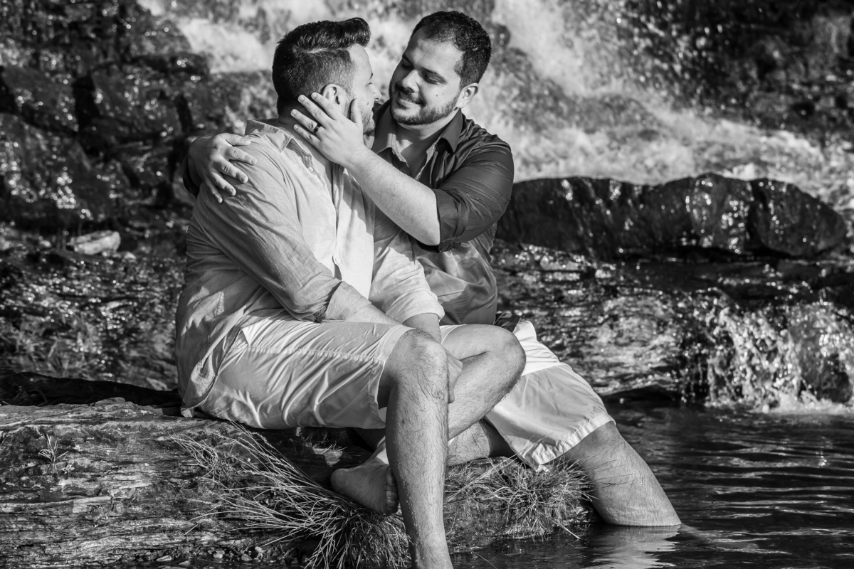 Um olho no olho incrível...o casal está sentado e em uma linda fotografia preto e branco, eles se olham e Victor coloca a mão no ombro e a outra no rosto do Jorge e o olha apaixonado.