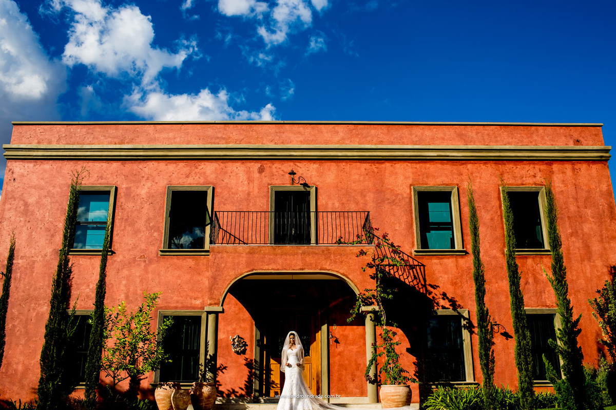 Beleza de uma noiva e a arquitetura espanhola, nesta linda fotografia colorida em conjunto com o céu azul.