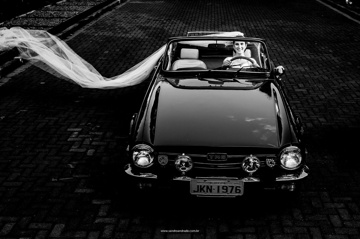 Lá vem a noiva em um possante antigo, sorriso estonteante e véu ao vento.