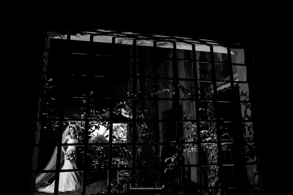 Linda fotografia criativa da noiva em preto e branco que o fotografo Sandro Andrade realizou utilizando uma grade como moldura