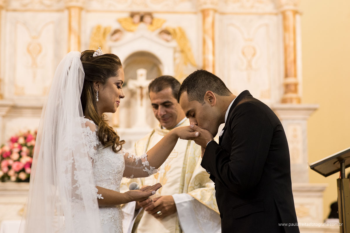 noivo colocando aliança na mao da noiva e beijando