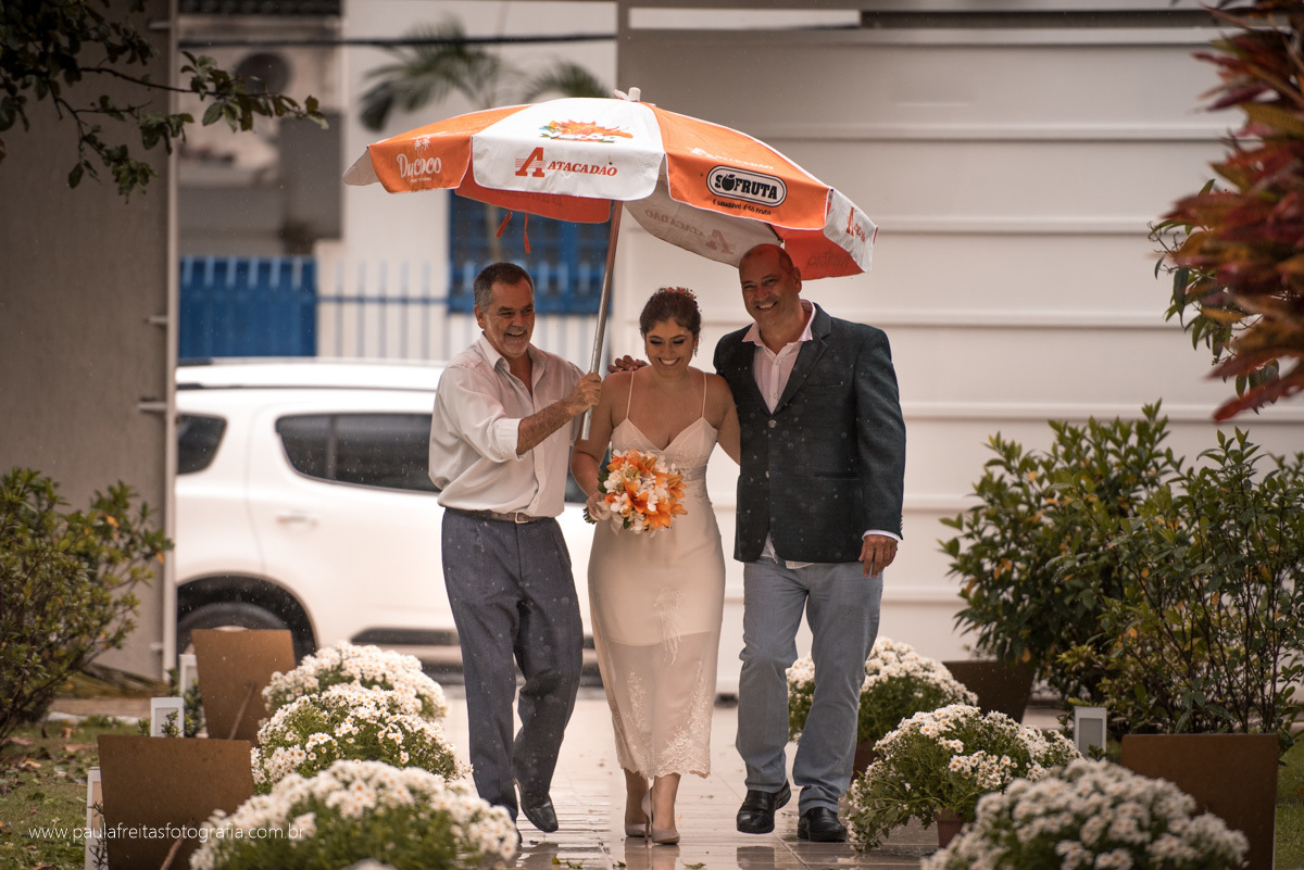 noiva entrando com seu pai de guarda chuva no seu casamento em guaratingueta por paula freitas