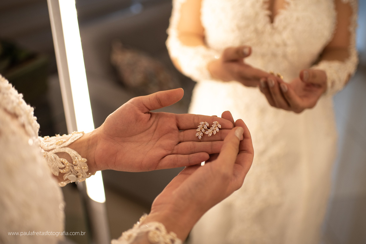 noiva segurando o brinco no seu makking of por paula freitas fotografia