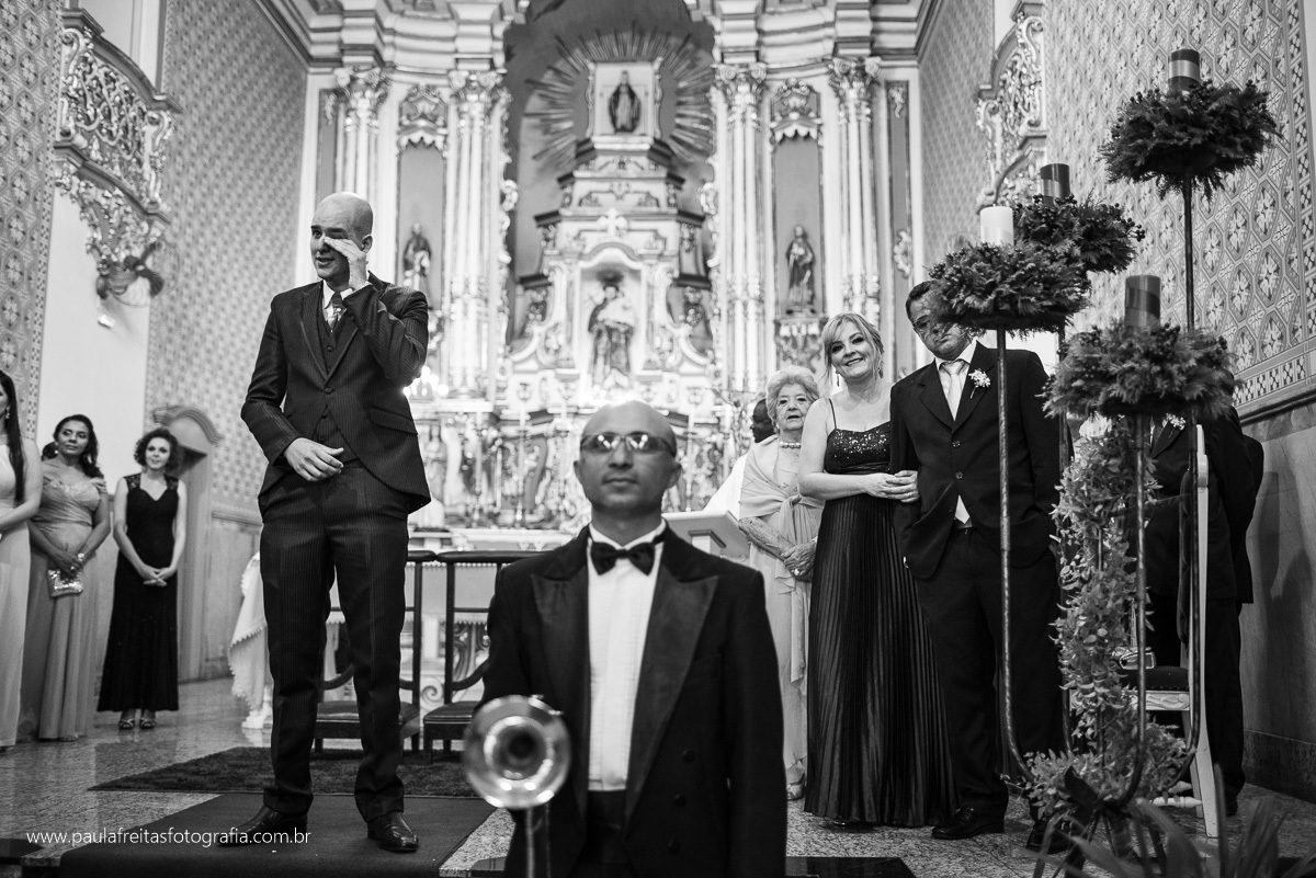 noivo chora ao ver a noiva entrando no corredor na igreja matriz de santo antonio em guaratingueta