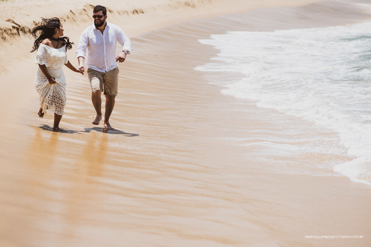 Fotos de casal correndo na areia da praia 