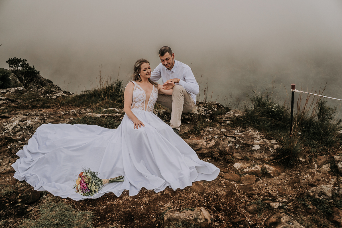 casal de noivos sentados a beira do canyon fortaleza em cambrá do sul
