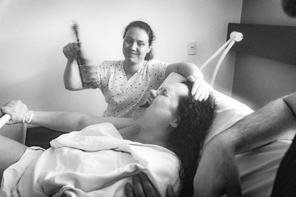 doula patricia momento em que faz vento e carinho na mamãe Lisi enquanto faz força apra o nascimento de sua filha Luna parto normal

