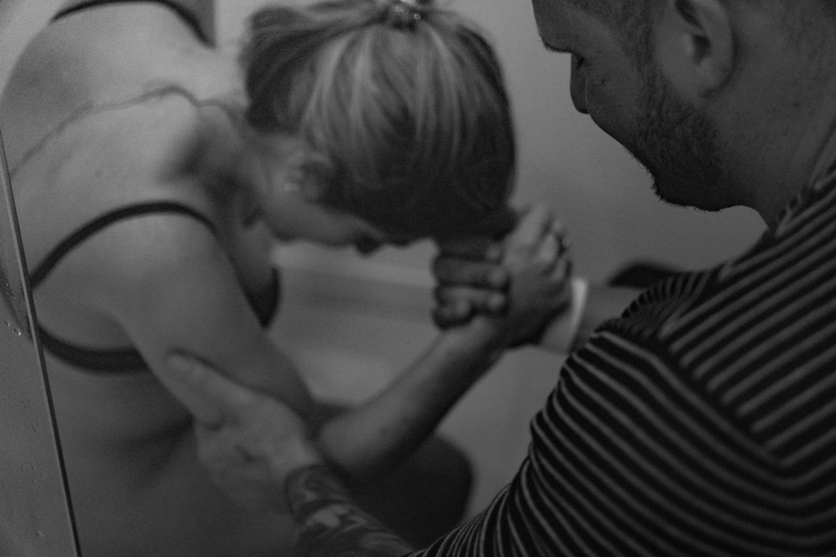 esposo ajuda entre uma contração e outra em trabalho de parto normal