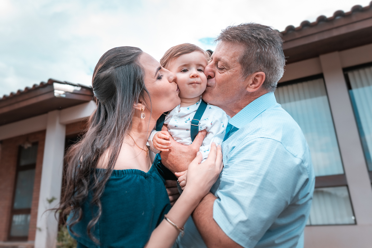 papai e mamãe beijando filho aniversariante