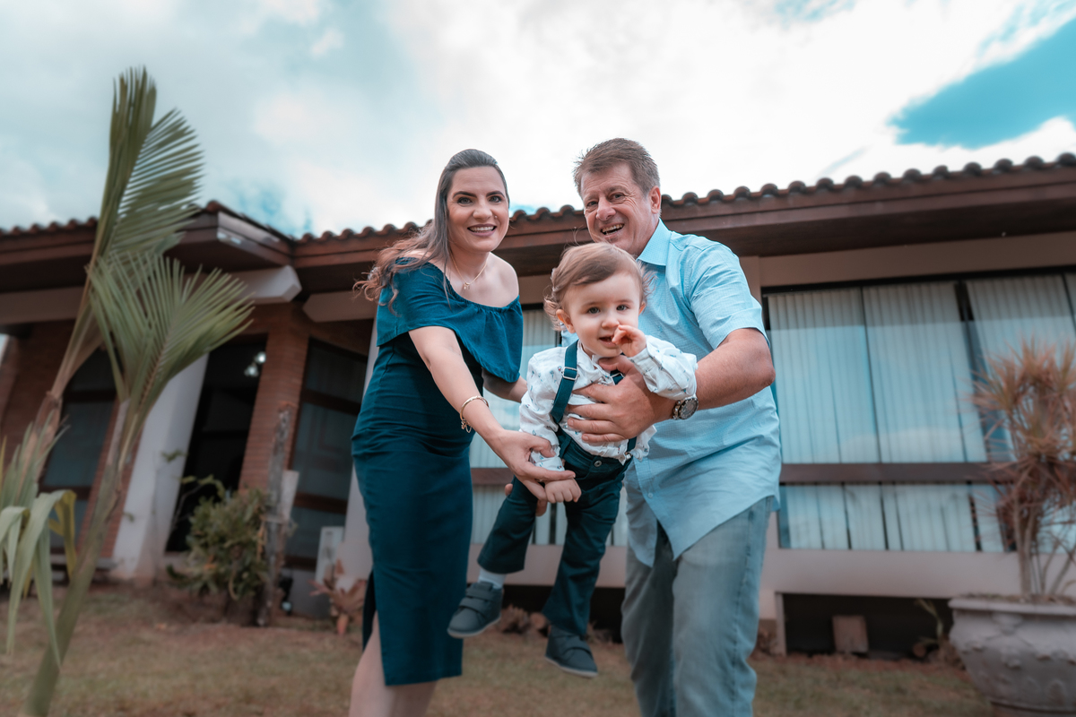 papai e mamae fazendo  aviãozinho com aniversariante fotografo de aniversario em erechim
