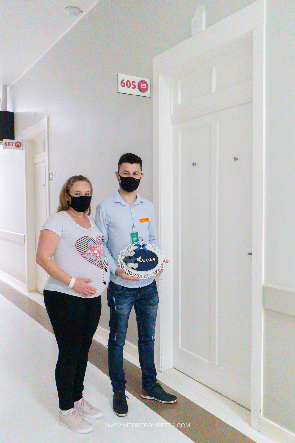 papais colocando a plada do nome na porta do quarto do hospital