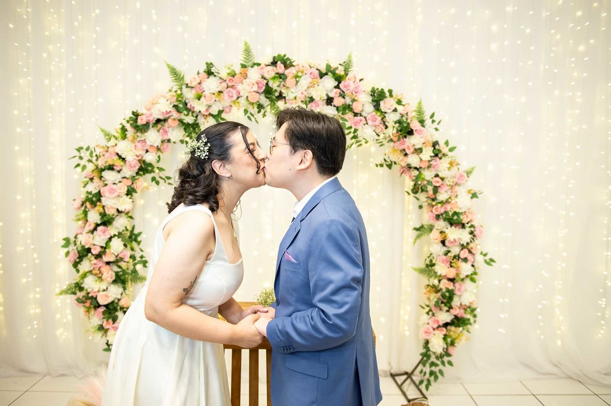 cerimonia-casamento-civil-cartorio-sp-detalhe-beijo-dos-noivos-decoração-atrás.jpg