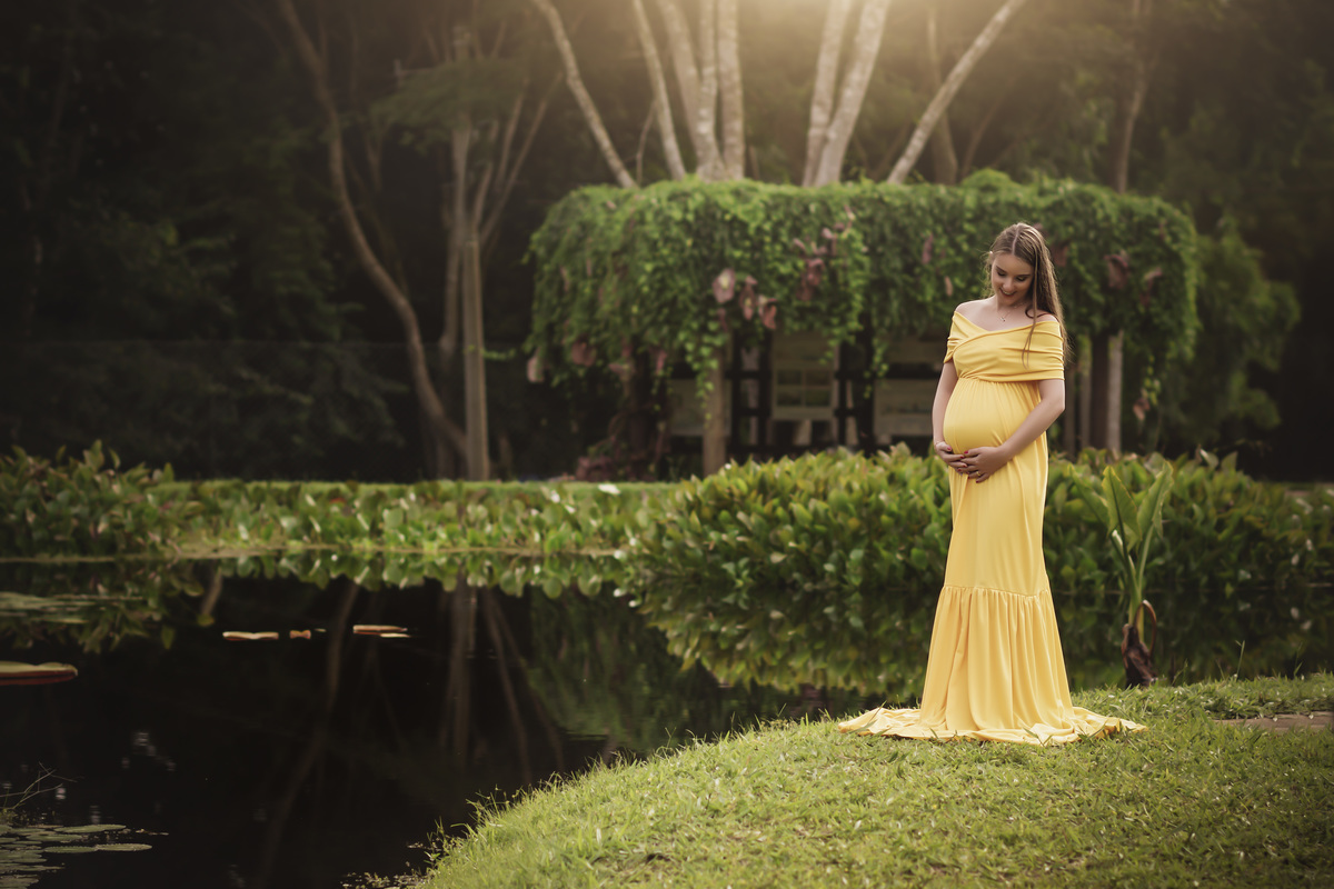 gestante de amarelo na beira da lagoa