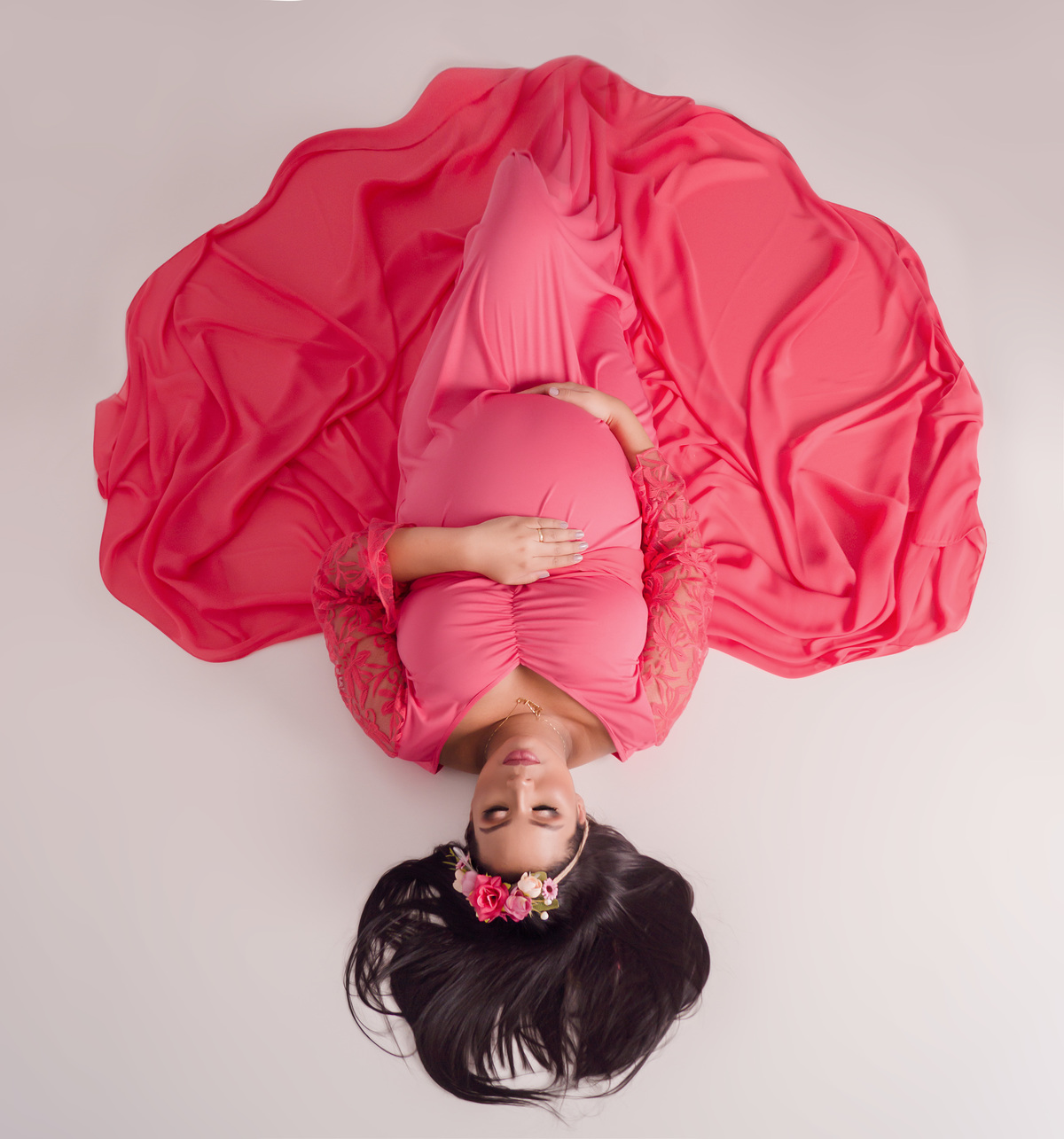 gestante de vestido rosa deitada