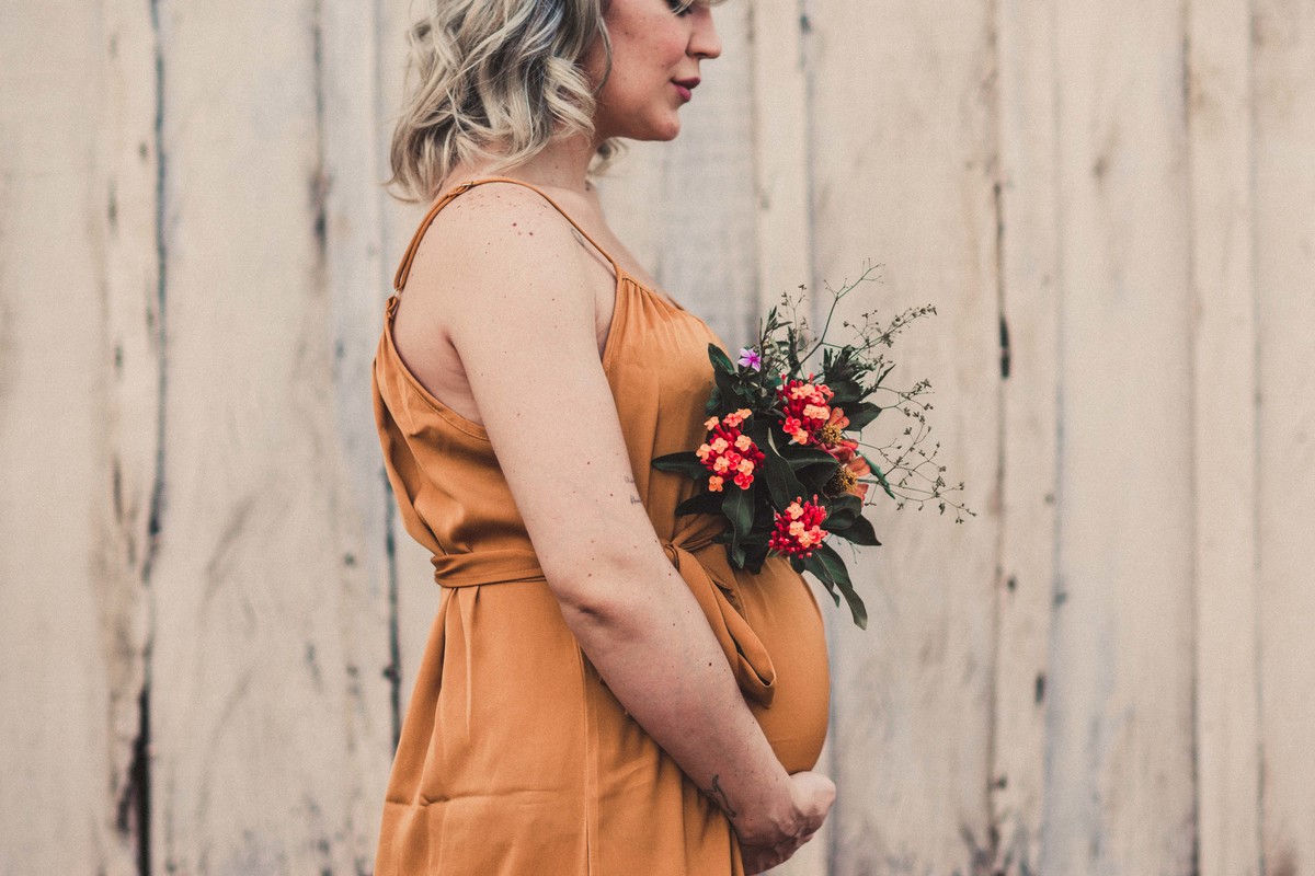 gestante segurando flores