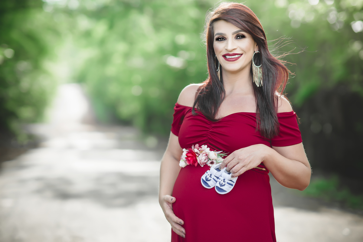 grávida de vermelho segurando sapatinhos