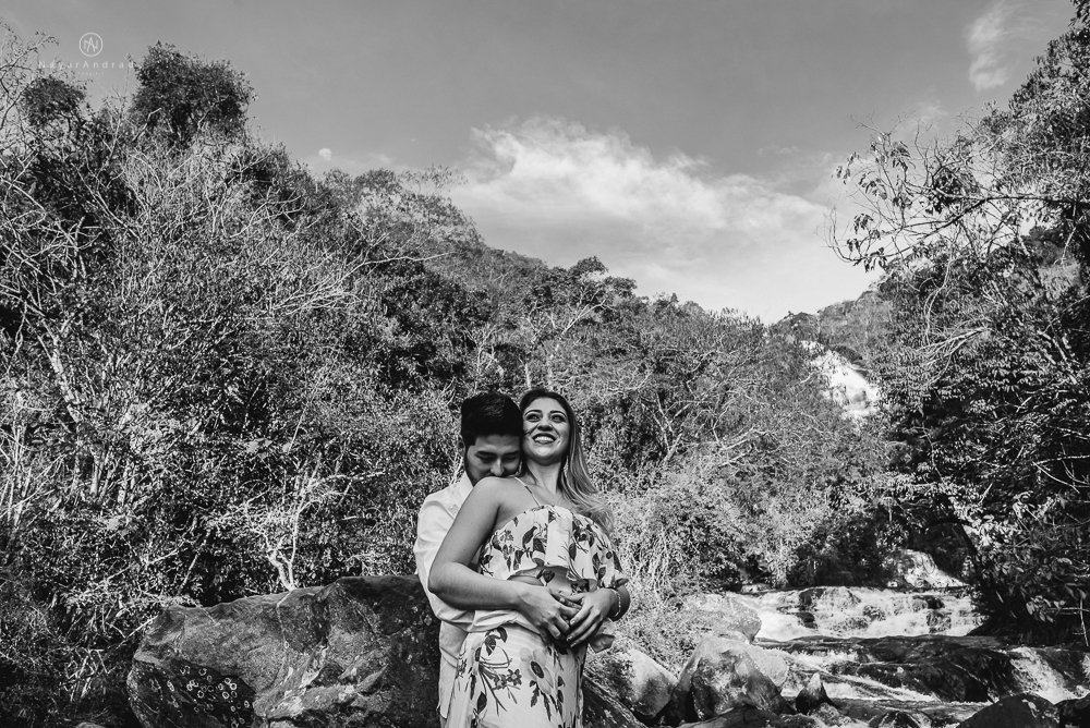 Ensaio casal pre-wedding na cachoeira com céu azul no entardecer.