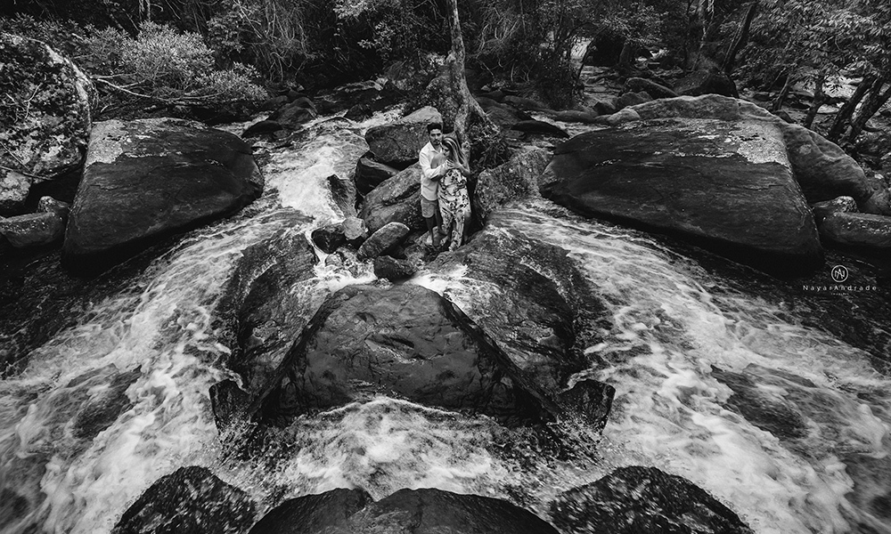 Ensaio casal pre-wedding na cachoeira com céu azul no entardecer.