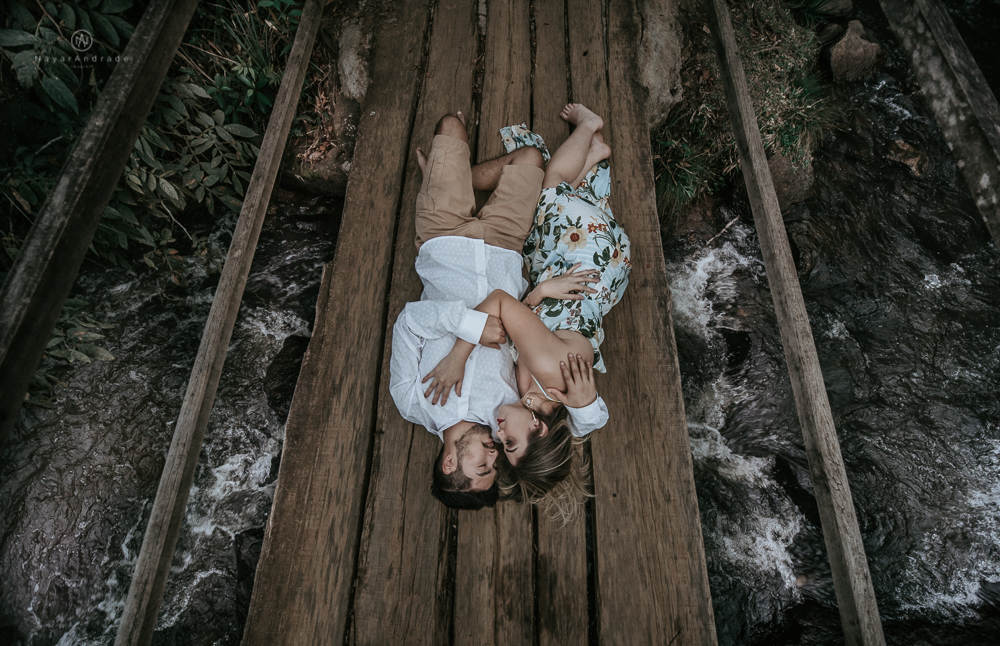 Ensaio casal pre-wedding na cachoeira com céu azul no entardecer.