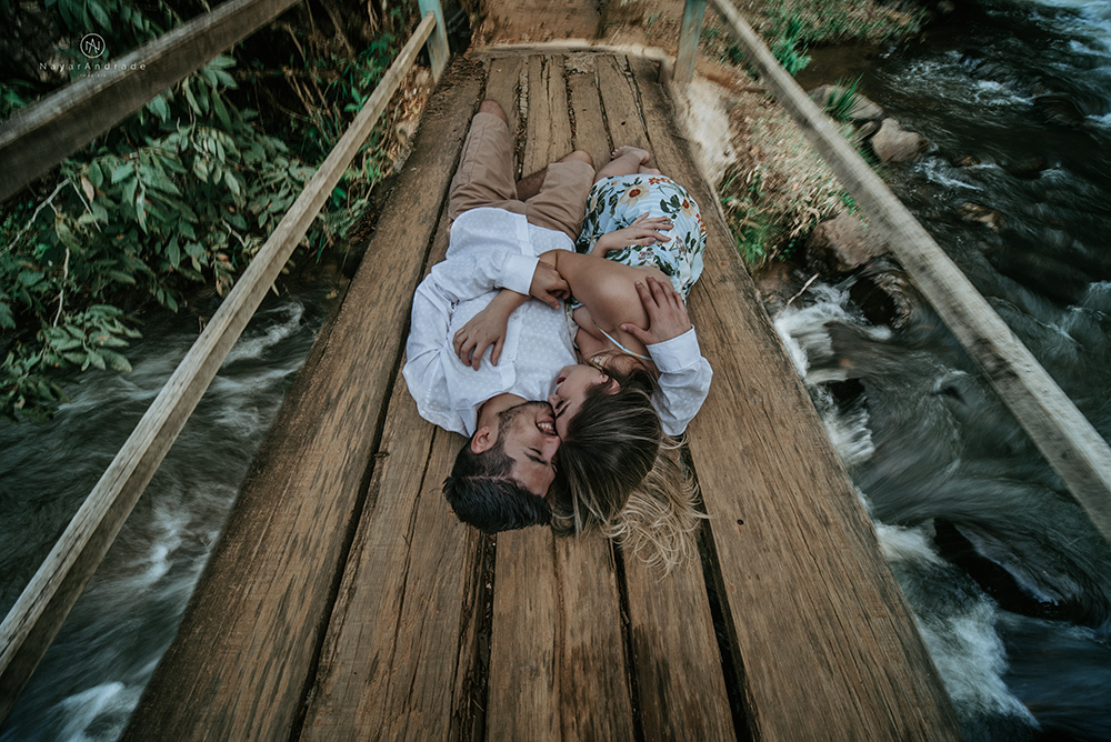 Ensaio casal pre-wedding na cachoeira com céu azul no entardecer.