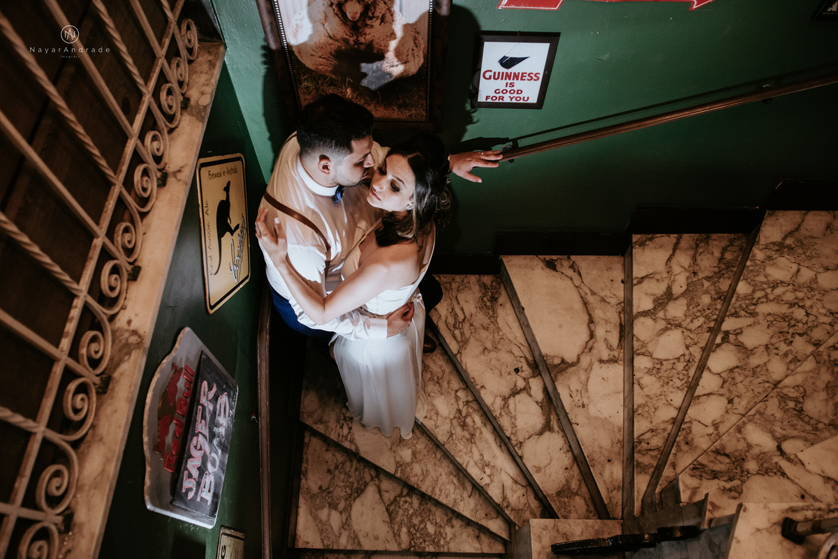 Mini wedding em Santos no australiano bar, noiva com vestido longo de fenda e noivo de suspensorio e gravata borboleta. Fotos de casamento na mesa de sinucae no bar. Casal apaixonado em mini wedd de manha