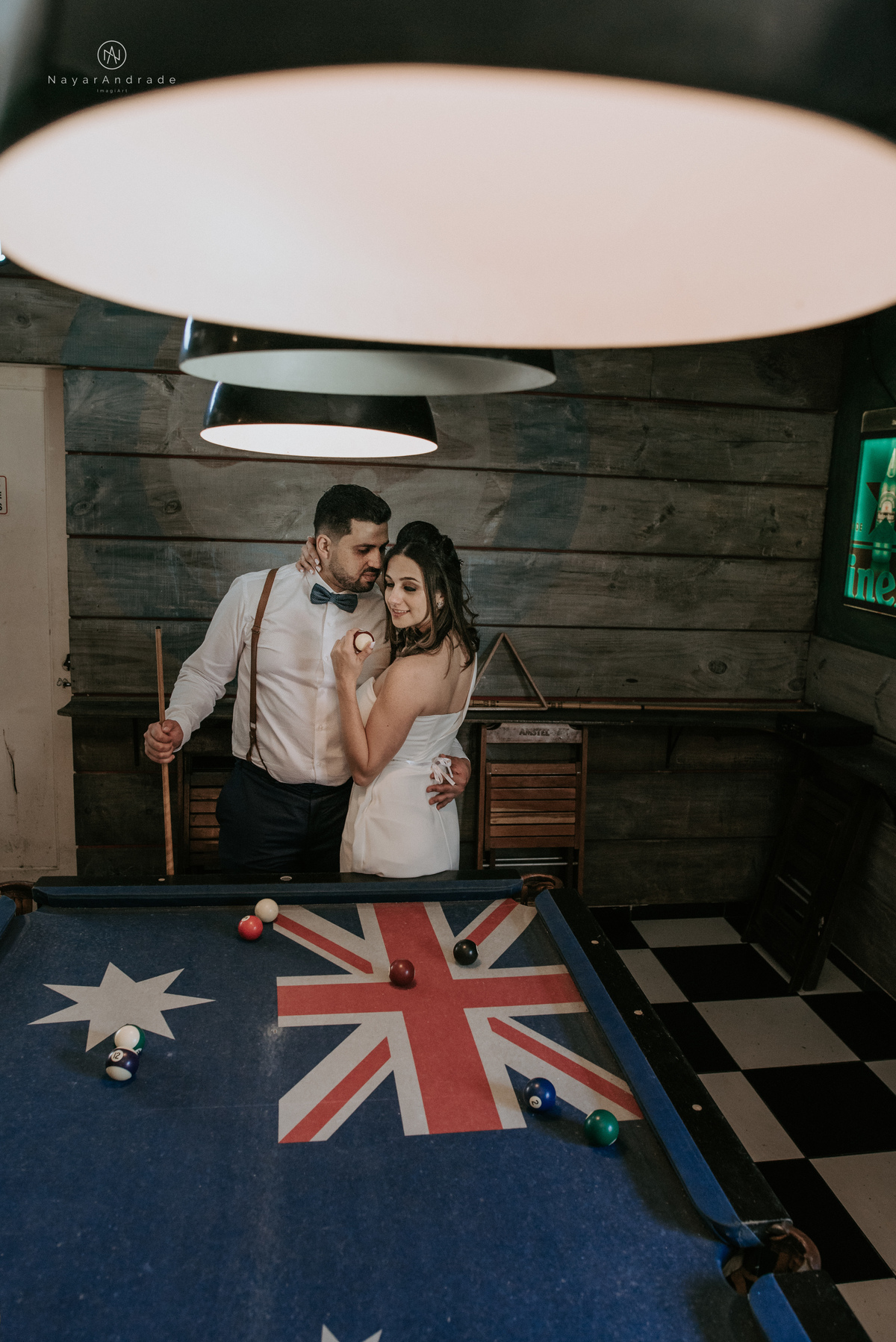 Mini wedding em Santos no australiano bar, noiva com vestido longo de fenda e noivo de suspensorio e gravata borboleta. Fotos de casamento na mesa de sinuca e no bar. Casal apaixonado em mini wedd de manha