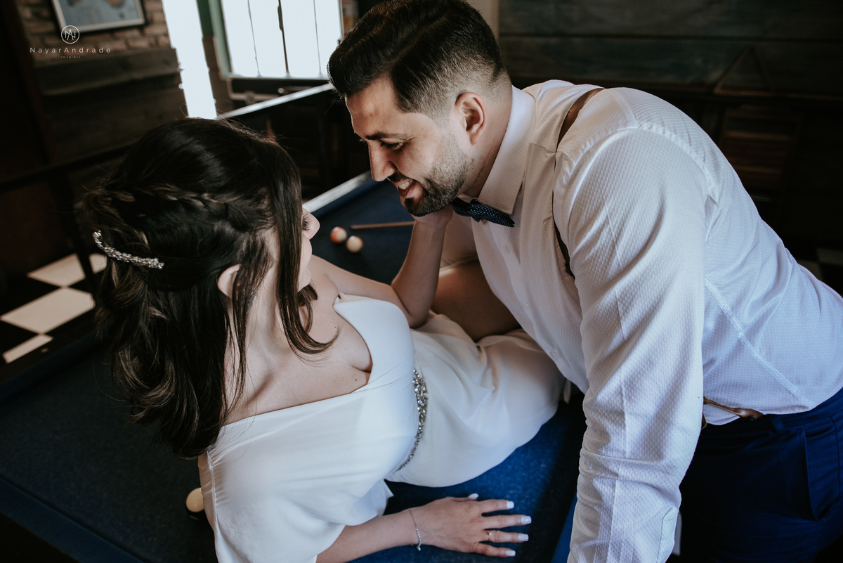 Mini wedding em Santos no australiano bar, noiva com vestido longo de fenda e noivo de suspensorio e gravata borboleta. Fotos de casamento na mesa de sinuca e no bar. Casal apaixonado em mini wedd de manha
