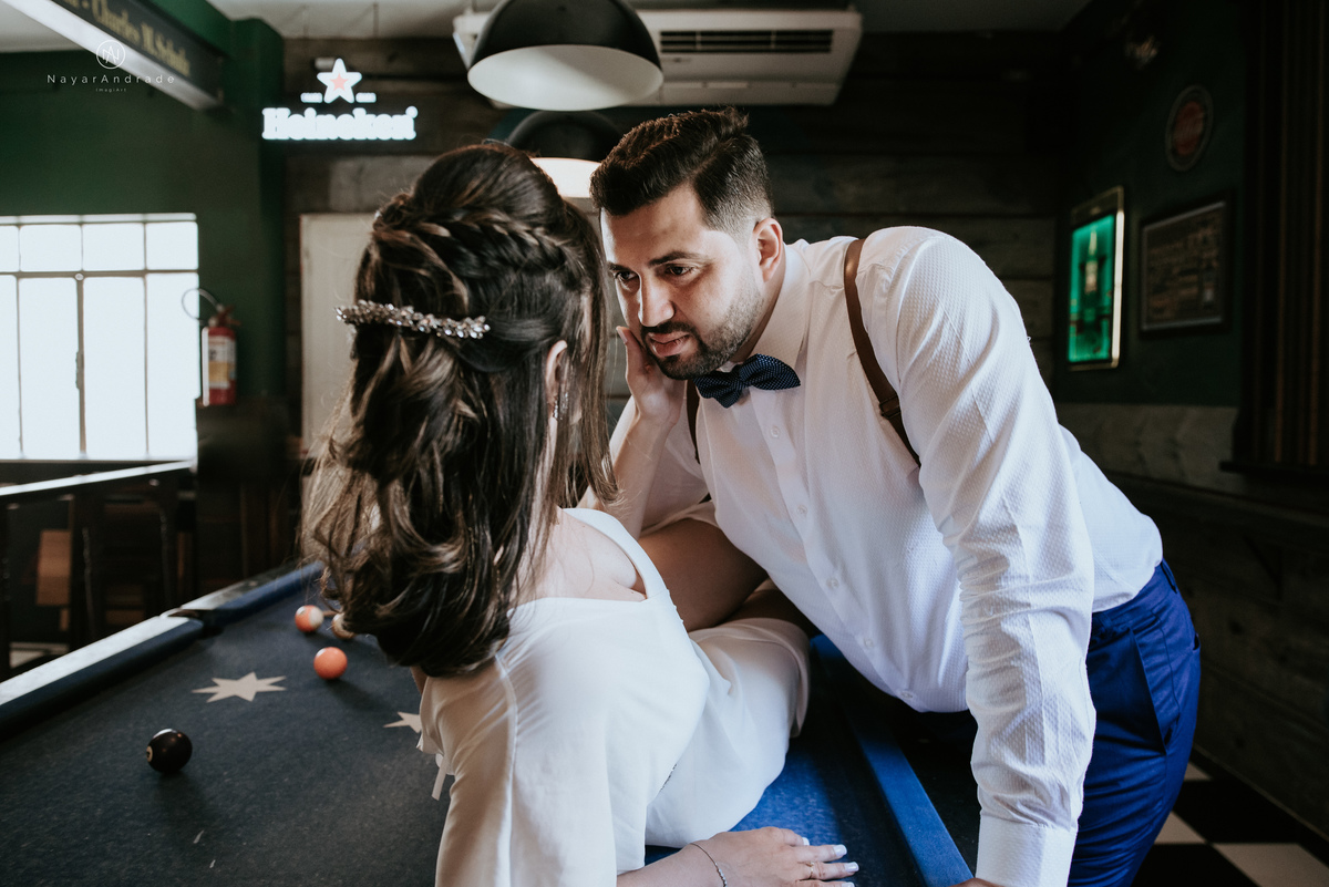 Mini wedding em Santos no australiano bar, noiva com vestido longo de fenda e noivo de suspensorio e gravata borboleta. Fotos de casamento na mesa de sinuca e no bar. Casal apaixonado em mini wedd de manha